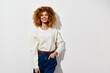© SHOTPRIME STUDIO - portrait of a smiling woman with curly hair in a light sweater against a neutral white background, embodying a casual and friendly vibe, ideal for lifestyle and fashion imagery