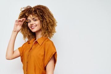 Wall Mural - Happy woman with curly hair, wearing a stylish brown shirt and smiling, captured against a neutral white background, showcasing a cheerful and warm vibe