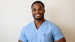 © MiguelAngel - Portrait of a black male nurse, in a blue lab coat, posing smiling and looking at the camera.