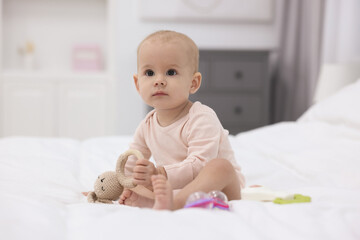 Wall Mural - Cute little baby with rattles on bed indoors