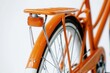 © Alla - A close-up shot of an orange bicycle against a white background, ideal for use in product photography or advertisements