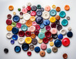 © Vitali - A scatter of multi-colored buttons creating a playful and creative contrast against a white background.