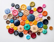 © Vitali - A scatter of multi-colored buttons creating a playful and creative contrast against a white background.