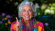 © El So - A smiling elderly woman of European descent, wearing a colorful scarf  pointing with finger.