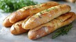 © Vadym - Four artisanal baguettes rest on grey surface. Fresh herbs decorate bread. Bread looks delicious, ready for sale. Image perfect for bakery promotion. High-quality close-up view displays texture,