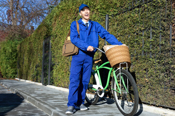 Poster - Postman with parcels in bicycle basket outdoors