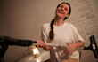 © My Ocean studio - A woman smiling and laughing while holding a vacuum cleaner hose. She is enjoying the cleaning process in a cozy home environment. She is dressed casually in a white t-shirt and beige pants.