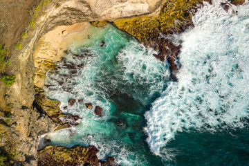 Canvas Print - Drone shot of tropical ocean waves crashing against a small beach at Broken Beach, Nusa Penida, Indonesia