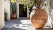 © Sampao - A handmade terracotta pot with natural imperfections sitting in a sunny garden.