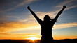 © Mavita - Silhouette joyful freedom hands raised at dramatic golden sunset sky with colorful clouds at mountain summit inspiring moment