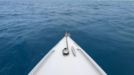 Wall Mural - Bow of a white boat sailing in a tranquil sea off the shore on a clear sunny day