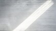 © Nuttaya Nampai - Rays of light creating abstract patterns on a white cement wall as sunlight streams through a narrow opening, ideal for text overlays.