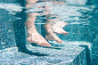 © Cavan - Underwater of toddlers feet in a swimming in a pool on a sunny day