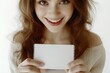 © Viktor - Bright smile radiates joy as young woman holds blank card, invit