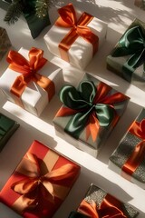 Festive presents with orange and green ribbons arranged on white surface.