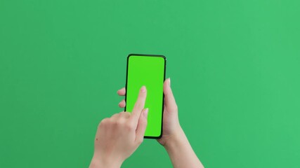 Young female hand touch smartphone with green screen on green background