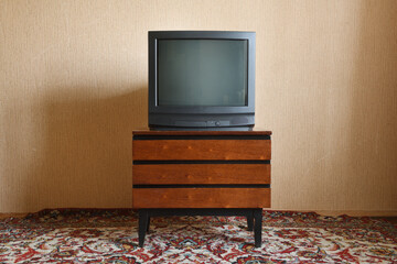 Vintage TV on wooden antique closet, old design in a home.Old black vintage TV.