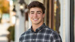 © InspirationDesign - Young man in plaid shirt with bright smile outdoors. Great for authentic portraits, casual style, or genuine happiness themes.