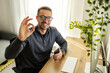 © Dusan Petkovic - Portrait of happy freelancer at home office gesturing okay at the camera.
