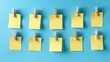 © andyaziz6 - Organize Ideas: Blank Yellow Sticky Notes with Wooden Clips on Blue Background for Planning, Reminders, and Note-Taking