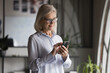 © fizkes - Serious middle-aged businesslady using on-line app on smartphone, enjoying modern technology, wireless internet, remote communication, typing text messages to client, smiling, look at cellphone screen