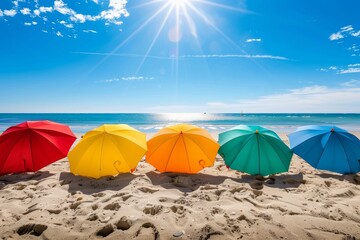 Wall Mural - Five bright umbrellas stand in a row on a sandy beach with the sun shining overhead, Bright sun shining on a sandy beach with colorful umbrellas