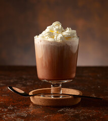 Wall Mural - Hot chocolate with whipped cream in a glass mug.