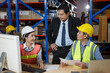 © iammotos - executive senior business manager meeting with asian warehouse worker checking storage inventory with computer and paper in storehouse