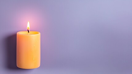 Wall Mural - A glowing yellow candle on a soft purple background, creating a serene and calming atmosphere.