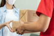 © Pormezz - Close up hand of delivery man send package box to receiver.