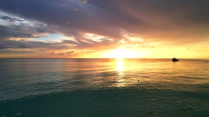 drone view of sunset over calm sea of seven mile beach in negril, jamaica