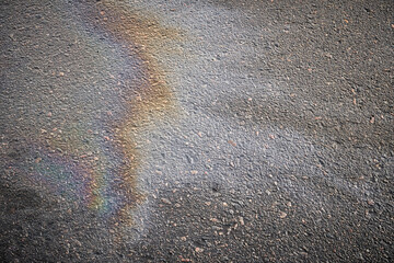 Wall Mural - Detailed view of oil stains on the road surface, showcasing the vibrant colors of gasoline as a captivating texture.