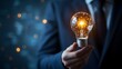 © Muhammad - Illuminating Ideas: A man in a formal suit tenderly holds a radiant light bulb, the internal filaments of which spark with innovation. The image portrays a fusion of concept and person.