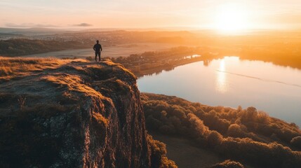 Wall Mural - Man Silhouetted Against Sunrise Over Scenic Lake And Valley