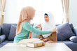 © DG PhotoStock - Asian muslim family's lifestyles concept. Woman get her daughter dressed.