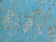 © Skyliz - fragment of iron painted surface with peeling blue paint as background grunge texture, peeling paint on wall with flakes and cracks in structure