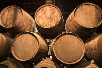 Toasted wooden retro style French and American oak barrels fermenting aged liquor such as wine, whiskey and rum in a underground basement seller at a vineyard’s winery and distillery