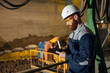 © Parilov - Engineer worker with clipboard conducts an inspection of automatic conveyor belt with clay for brick production, ceramic factory