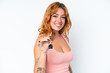 © luismolinero - Young caucasian woman holding home keys isolated on white background smiling a lot