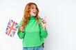 © luismolinero - Young caucasian woman holding an United Kingdom flag isolated on white background intending to realizes the solution while lifting a finger up