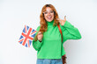 © luismolinero - Young caucasian woman holding an United Kingdom flag isolated on white background giving a thumbs up gesture