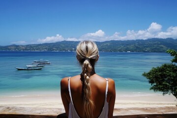 Wall Mural - Young caucasian female overlooking scenic beach and ocean from wooden deck