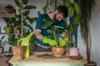 © VSzili - Man planting houseplants indoors home gardening