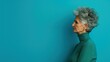 © ChimE - A portrait of a sad elderly woman against a soft blue backdrop, perfect for conveying deep emotions and introspection.