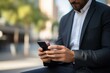 © nsit0108 - Businessman is using smartphone outdoors, typing message on mobile phone, urban background