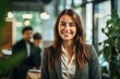 © nsit0108 - Portrait of a smiling businesswoman in modern office with colleagues working in the background
