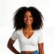 © Viktor - Happy African American woman poses for portrait. Smiling young lady with curly hair wears white crop top. Beauty, fashion photo on transparent background. Woman expresses joy. Stylish model in simple