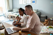 © Davor - Family having breakfast together at home with toddler and laptop