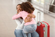 © Prostock-studio - Meeting In Airport Concept. Little black girl embracing her happy mother after arrival in airport, returning back home from vacation journey voyage, smiling lady hugging daughter