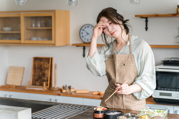 キッチンでお弁当を詰める女性（疲労・疲れ・大変・負担・過労・苦労）
